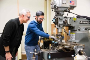 Taha Al-azzawi ’18 and Dr. Daniel Black watch as the newly automated drill completes a project.