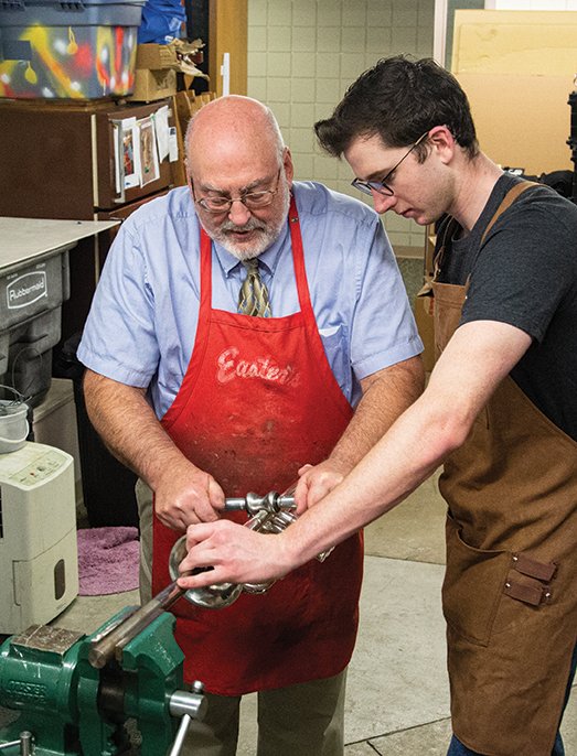 Dr. Craig Hancock and Logan Merley '20 repairing a trumpet