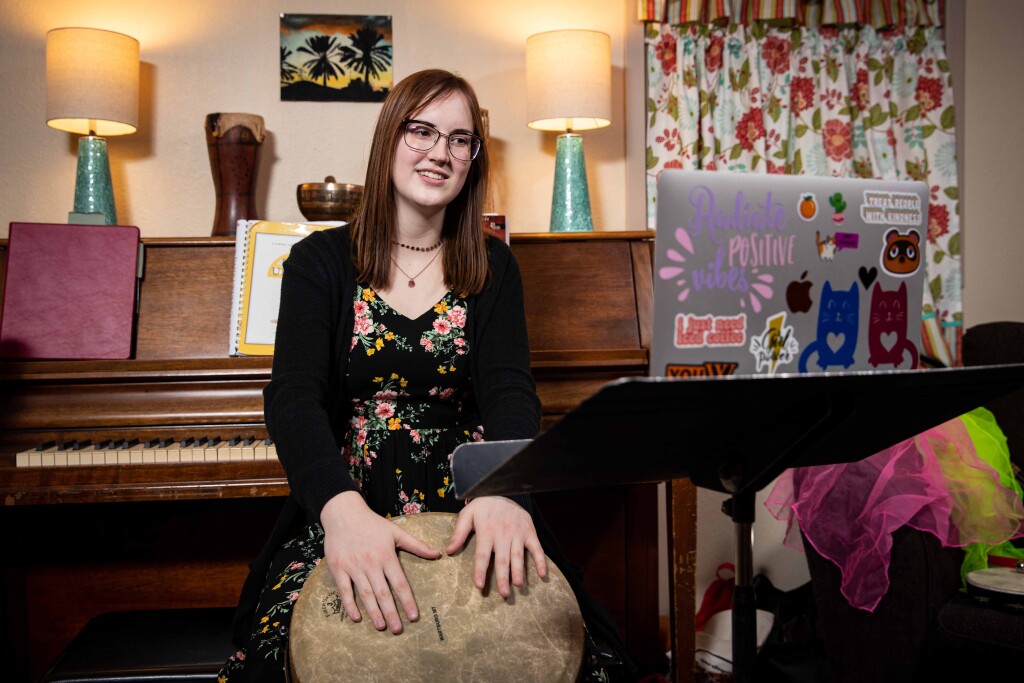Natalie Camp plays a drum during a teleheatlh music therapy session.