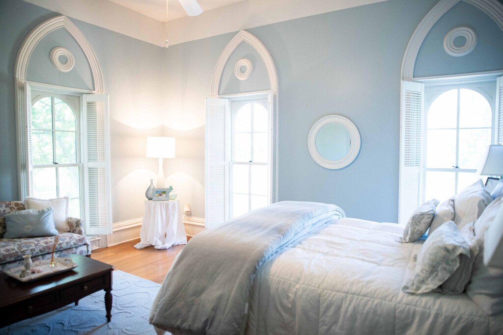 The decorative plaster arches and medallions inside the Blue Room, a guest bedroom at Greenwood, are a replication of the originals that were uncovered during renovations.