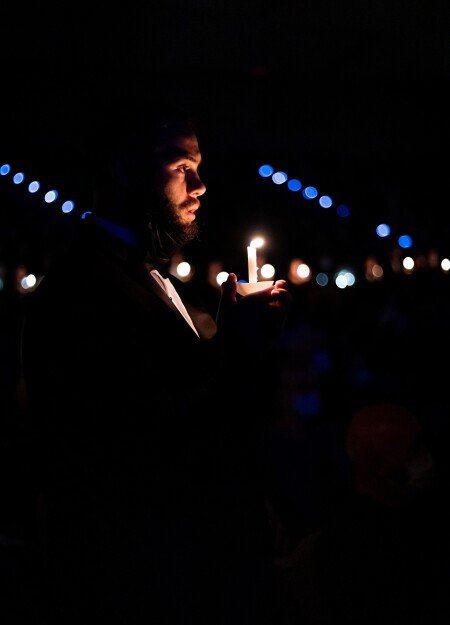 A student prepares to blow out his candle during a 2021 Christmas with Wartburg performance.
