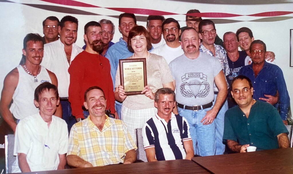 Margie Mowry Ketterer is pictured with numerous men from the HIV/AIDS support group she facilitates when they honored her in 1999 for her service.