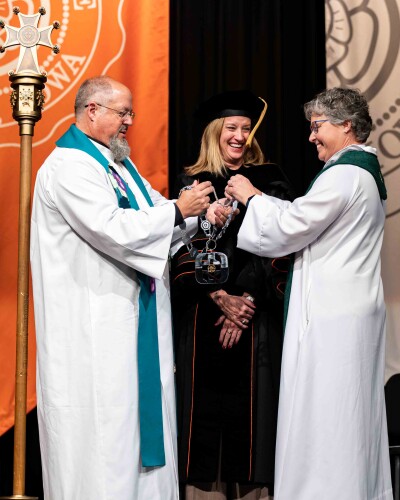 President Rebecca Neiduski accepts the Chain of Office from Bishops Kevin Jones and Amy Current.