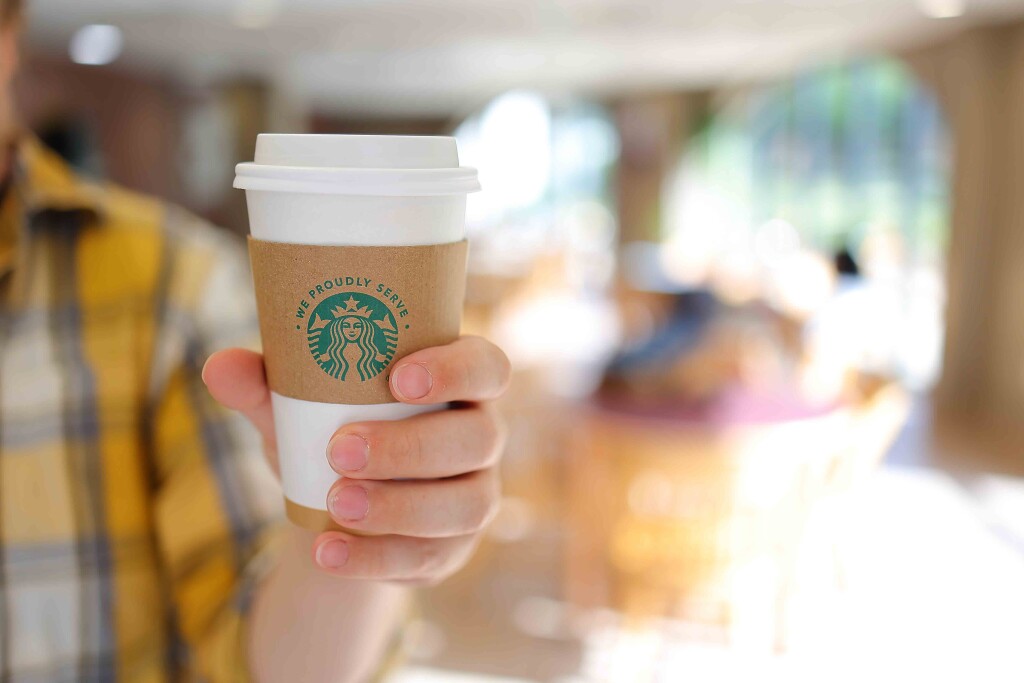 Starbucks cup in a person's hand in the konditorei