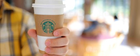 Starbucks cup in a person's hand in the konditorei