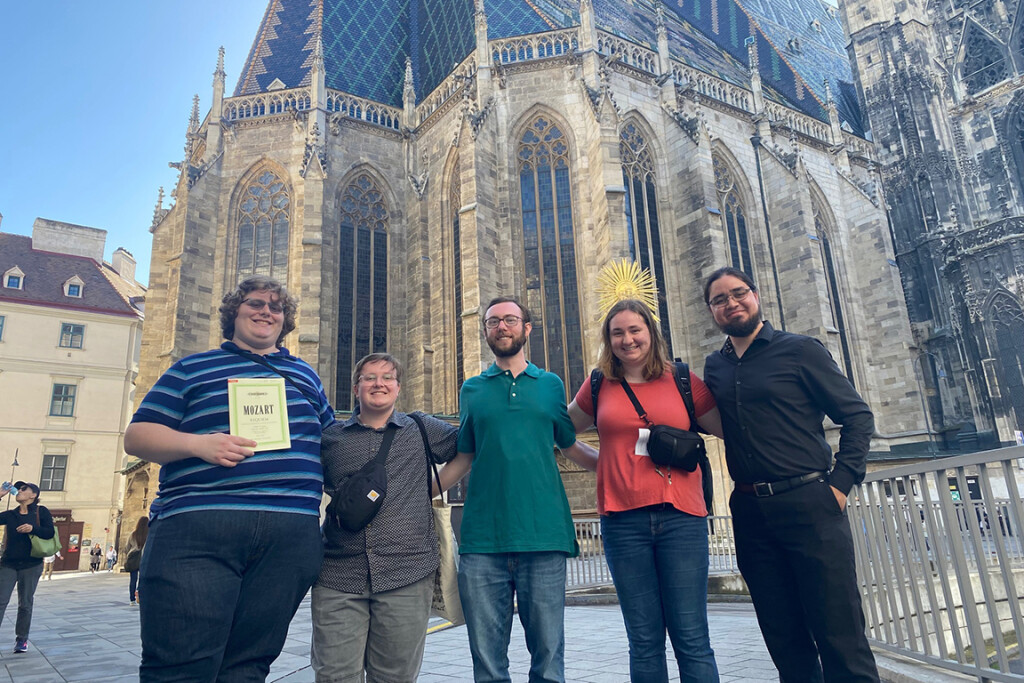 Five Wartburg students stand in front of a historic church while traveling abroad.