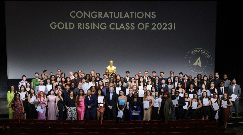 Lauren Ulveling and the other 99 students who completed the Academy Gold Rising Internship Program pose on a stage.