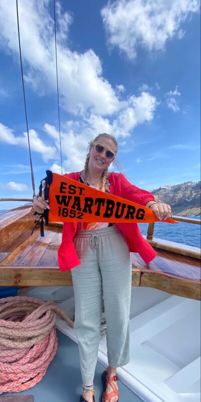 Jacy Werning holding Wartburg pennant on boat in Greece
