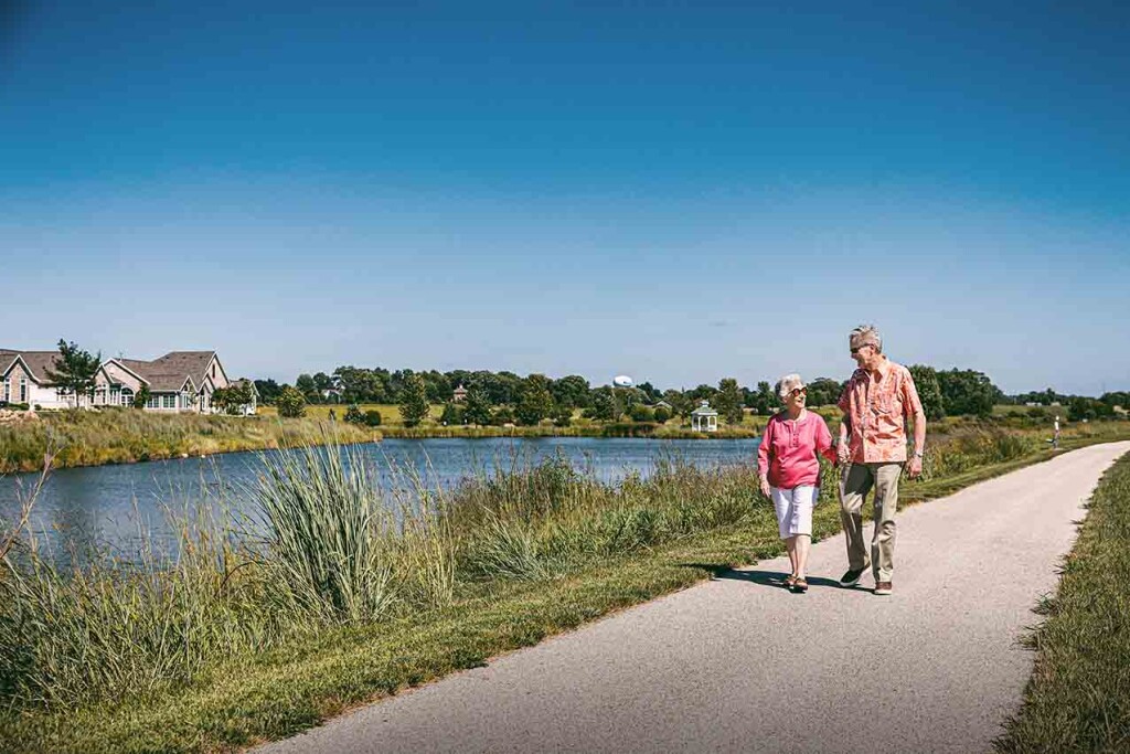 Rennie Fiegen Scharlau ’61 and Ed Scharlau ’61 walk along the pond at EIsenach Vill