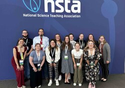 Wartburg college students and professor Michael Bechtel at the NSTA conference standing in front of the NSTA backdrop