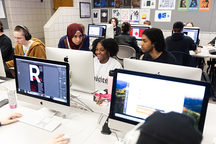 Professor Marwa Elkashif works with students during a graphic design class.