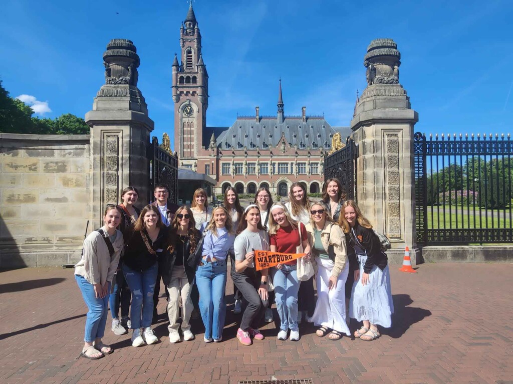 Wartburg students stand in front of a historic building while traveling in the Netherlands and Germany as part of the People, Planet and Profit May Term course