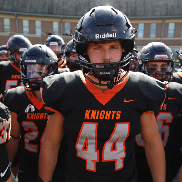 Owen Grover leads the Wartburg Football team onto the field.