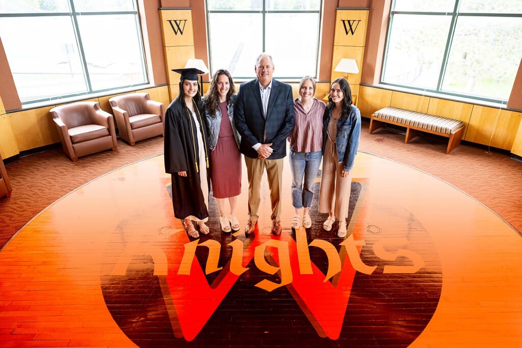 Jaedon Murphy ’25, Miranda Murphy Gerdes ’18, Mike Murphy ’89, Megan Murphy Logan ’18, Riley Murphy ’21 stand on the center court logo from the former Knights Gymnasium where Mike played as a student.
